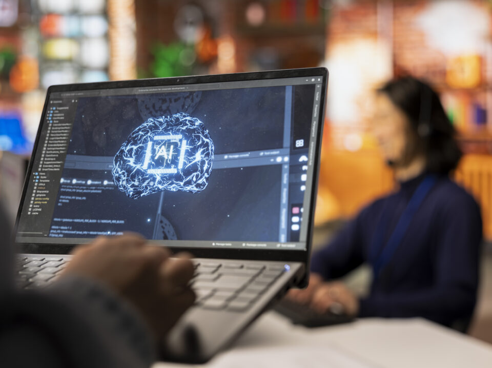 Call center worker uses AI technology on laptop to provide quick replies to common customer queries, close up. Customer service agent generates automated responses to clients using AI tech on notebook